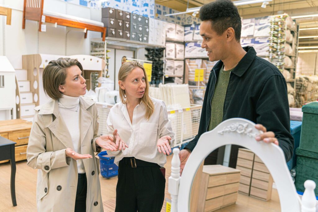 Customers discuss furniture choices with a retail assistant in store